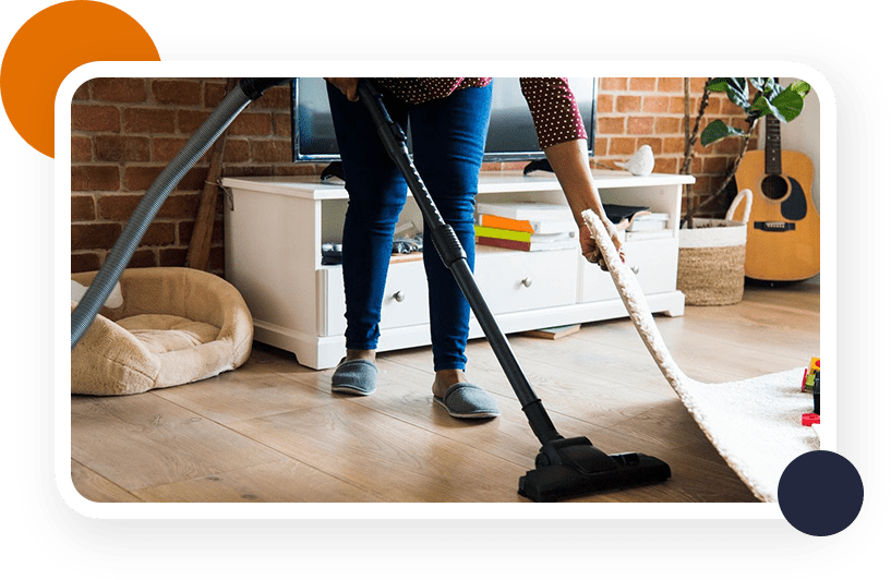 A woman is vacuuming the floor in her living room.